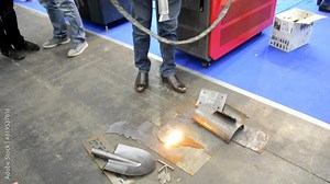 Laser cleaning of metal. Industrial laser cleaning rust of metal. Industrial removal of rust of metal surface with laser beam. Man cleaning surface from corrosion with laser metal cleaning machine