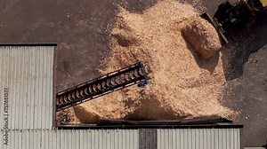 Transporting Wood Chips With Conveyor And Loader At Sawmill. topdown shot