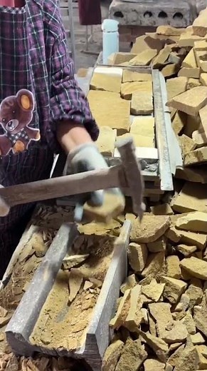 Workers are cutting stones using hammers so that they fit into the arrangement.
