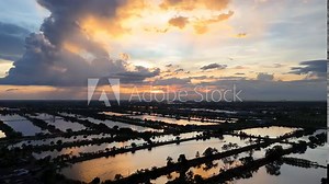 Aerial view of rice fields Drone photo of beautiful orange sky with rice fields in rural Asia. Movie rice field with water source Indian rice fields in growing season