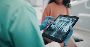 Clinic, patient and dentist with tablet screen for x ray, teeth diagnosis and dental structure in appointment. Healthcare, person or doctor with tech for orthodontic procedure or planning for surgery