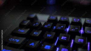 Glowing keyboard hackier style glittering at the night workplace with different light colors