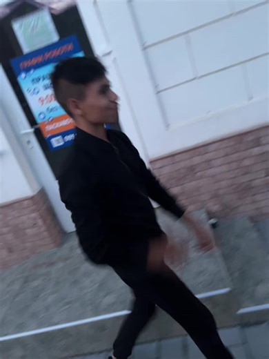 Person Walking Alongside a White Facade Building