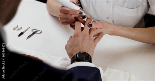 Manicure master working with male client in beauty salon. Men's nail care