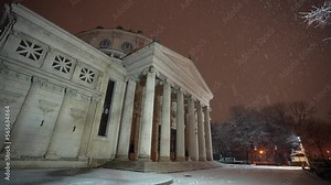 Winter night in Bucharest. 4K wide angle still video during a beautiful snowfall at the Romanian Atheneum landmark from Bucharest, Romania.