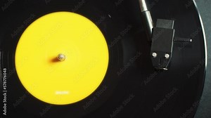 Retro Vinyl record player playing music, close-up macro shot of vintage LP disc old phonograph spinning. Retro music player at home.