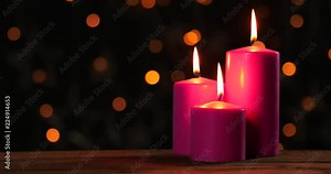 Burning Christmas candles with blurred sparkling lights background. Shot in 4k resolution