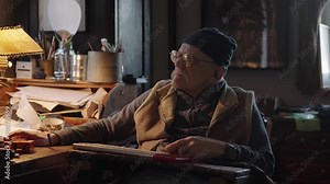 Senior adult working with computer by the desktop sitting in wheelchair