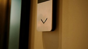 close-up of a man presses a button to call an elevator in hotel or high-rise building technology and travel