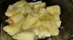 cassava fried in a black frying pan with hot oil. A snack that can be made easily and affordably, and has a delicious taste.