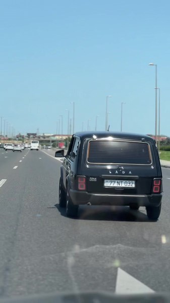Vintage Black Station Wagon Driving on Highway