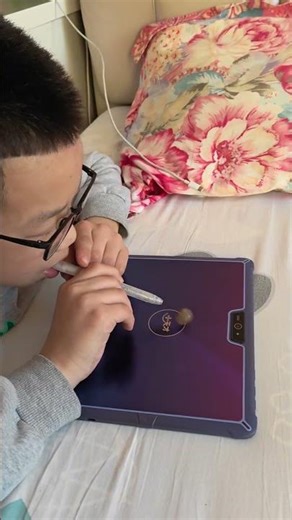 Boy spins coin using stylus on device in Heilongjiang, China