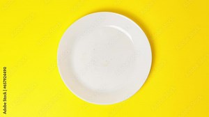 Eating delicious sweet donut covered with chocolate glaze on bright yellow background. Stop motion food donut animation video. Bakery and food concept. Top view of chocolate doughnut in 4K