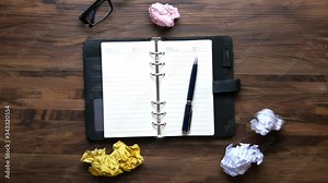 dropping crumpled paper ball on notepad