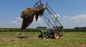 Big Tractor Power is out in the field with a 55 hp JOHN DEERE 2510 Tractor stacking loose hay with a JOHN DEERE 52 Hay Stacker.  bigtractorpower