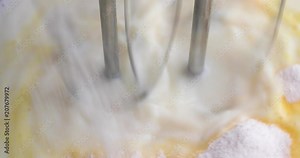 Adding dry banana cream pudding mix to fresh milk while being mixed with dual electric beaters.