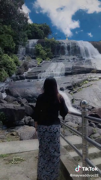Woman Enjoying Scenic Waterfall View in Nature