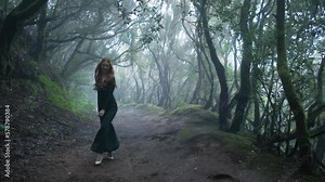 Beautiful woman in an elf costume is walking in a magic green enchanted forest. Stock Video