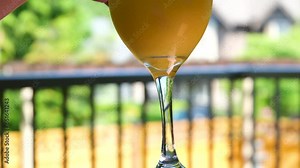 drinking orange juice with ice close-up glass straw pulling through a straw cold drink stirring ice cubes cooling summer. drinking in the heat