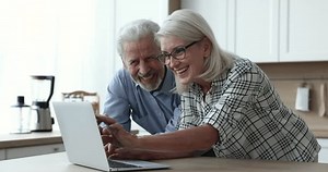 clip-1103218565-happy-older-couple-talking-using-laptop-doing