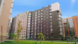 A modern multi-storey brick residential complex with a private landscape. Newly built multi-storey residential complex in a residential area with landscaping around the house.