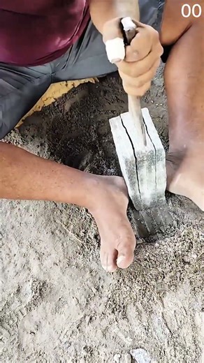 Splitting concrete block manually with chisel and hammer