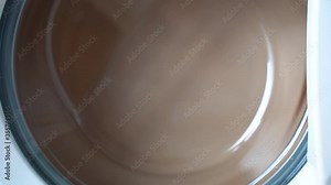 Close-up drying stage gradually speed increasing of washing machine. View of the glass door, clothes rotate very fast. Drying stage of front load washing machine. Laundry Machine.