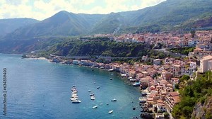 Scilla uno dei borghi più belli d'Italia vista panoramica dall'alto mostra la linea di costa con le case sull'acqua di Chianalea ed il porto turistico con barche e gommoni sul mare