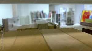 Open book with fanned pages. Stack of hardback paper books on wooden bookshelves. Library bookcase in a row. Books stacking. Back to school. Education, reading moving forward along shelves