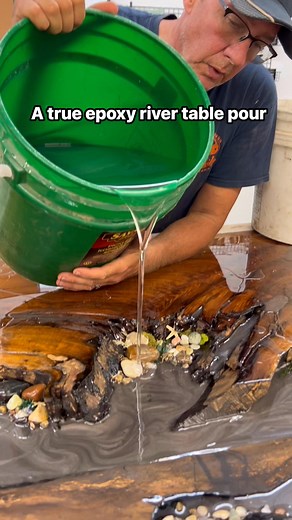 A true epoxy river table pour! An English walnut slab is the perfect choice along with river stones, moss, shells, and even Petosky stones! We use WiseBond Deep Pour & Table Top Epoxy to create this one of a kind table. #tdeezbadasscreations #epoxy #rivertable #wisebondepoxy #oxfordindiana | TDeez Creations