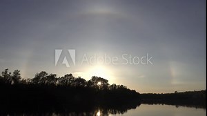 Unusual atmospheric phenomena. Very bright double halo (parhelic ring) over river at moment of evening sunset, windless spring day. Average flow of Don River. Mock sun with reflection in water Stock Video