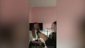 Two schoolgirls throw a pair of kittens high into air and laugh