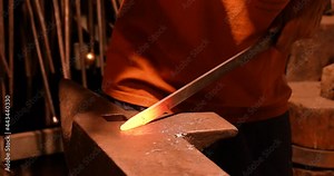 Close up of a craftsman smith's forging a sword with hot iron, hammering in an artisan way by hand with italian craftsmanship.