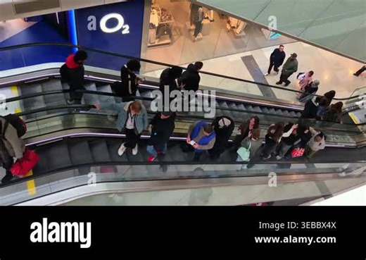 London, UK - October 27, 2025:Crowd of shoppers moving up and down escalators in a shopping center, symbolizing consumer activity, retail environment, busy lifestyle, and modern urban commerce Stock Video Footage - Alamy