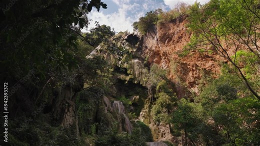 Multi tier limestone cascade of Erawan Waterfall surrounded by tropical forest in Erawan National Park, Kanchanaburi, Thailand. Famous natural attraction with lush jungle scenery.