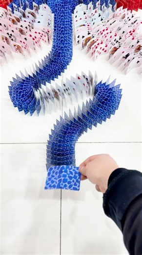 Arts Promote 🎨 on Instagram: "Longlong Who Loves Arranging Cards is a Chinese creator known for building intricate domino-style setups using playing cards. He carefully places each card on the floor, designing complex paths, curves and patterns where every position matters. Once everything is perfectly aligned, he tips the first card and lets the chain reaction unfold, revealing a smooth, satisfying domino effect that highlights both planning and creativity. His videos combine patience, precisi