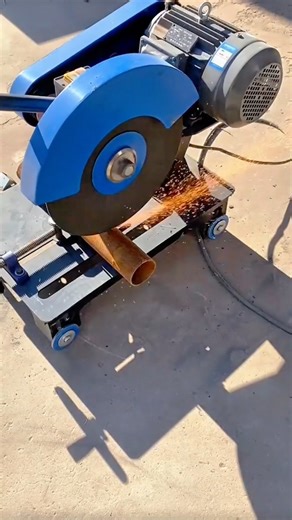 Powerful chop saw machine cuts through a metal pipe creating sparks and heat