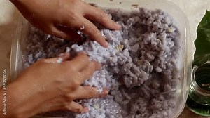 Top view of hands mixing soaked recycled paper to make paper mache mixture for a sustainable zero waste lifestyle