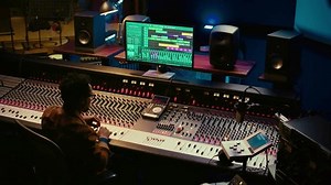 African american audio expert adding sound effects on tracks in post production, operating mixing console and pushing sliders. Producer creating music for his new album, audio mixer. Camera B.