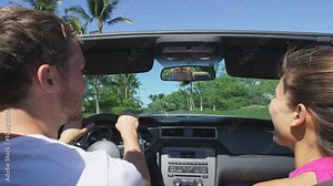 Couple driving car on road trip travel vacation in convertible. Young romantic couple on travel holidays vacation laughing smiling having fun. Man driver behind steering wheel. RED EPIC, SLOW MOTION. Stock Video