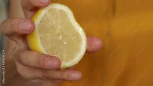 Hand squeeze fresh lemon, juice drains from the pulp and drips. Squeezing out Lemon juice.