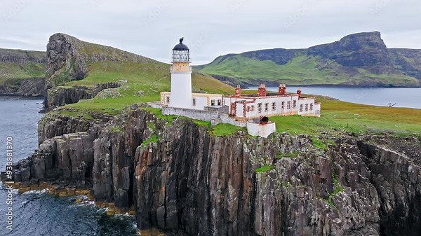 Aerial view of Lighthouse on a rocky cliff-top overlooking a causeway and the coastline in Scotland. Travel destination, tourist attraction landmark of Scottish Neist Point Lighthouse on Isle of Skye.