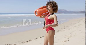 Female lifeguard looking into distance on beach
