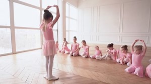 Girls dancers in ballet school learns to dance. Little Ballerinas in training in pink dancing suit. Children's ballet school. School of ballet.
