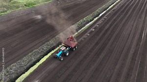 Peat Harvester Tractor on Collecting Extracting Peat. Mining and harvesting peatland. Area drained of mire are used for peat extraction. Drainage and destruction of bogs. Peat harvesting.
