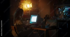 Hispanic Female Web Designer Using Old Desktop Computer In Retro Garage Late At Night. Focused Internet Enthusiast Writing Code At Home. Programming Successful Social Network Website In Nineties.