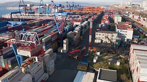 Download Reach stacker loading a container onto a car trailer at a container terminal