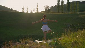 Yoga Workout of Female Athlete. Young Healthy Woman Doing Yoga in the Mountains During Sunrise. Wellbeing and Healthy Lifestyle, Zen Concept. Slow Motion.