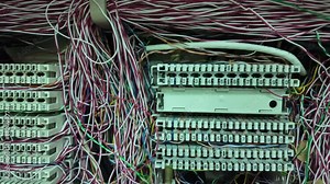Inside a PABX telephone booth that has a number of connecting cables in many colors in the analog system. communication technology