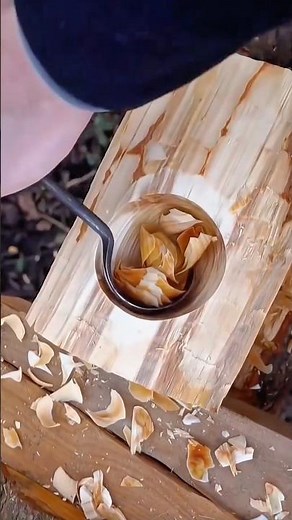 Using a long spoon gouge to excavate and shape the deep interior of a wooden block